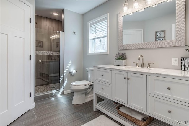 full bath with recessed lighting, toilet, vanity, baseboards, and a stall shower