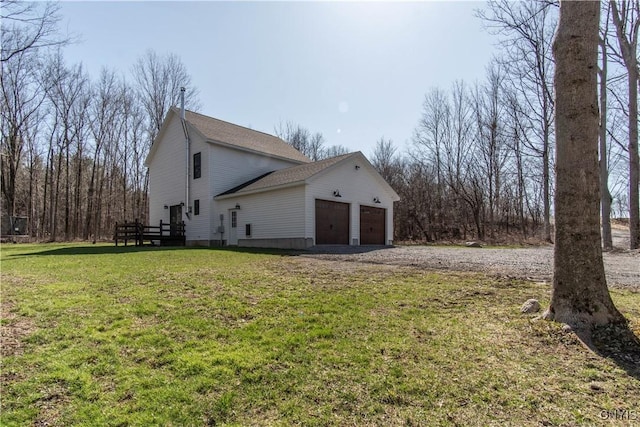 view of side of property with a wooden deck, a garage, a yard, driveway, and roof with shingles