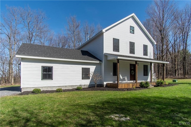 view of front of house featuring a shingled roof, a porch, and a front lawn