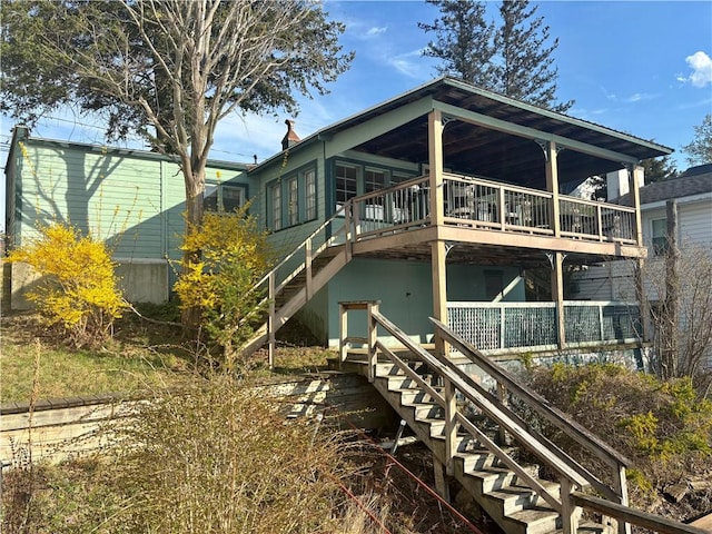 rear view of house with a wooden deck and stairway