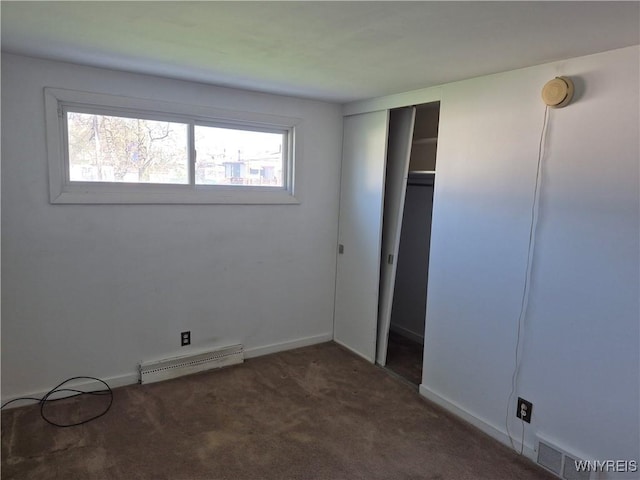 unfurnished bedroom with visible vents, baseboard heating, baseboards, a closet, and carpet