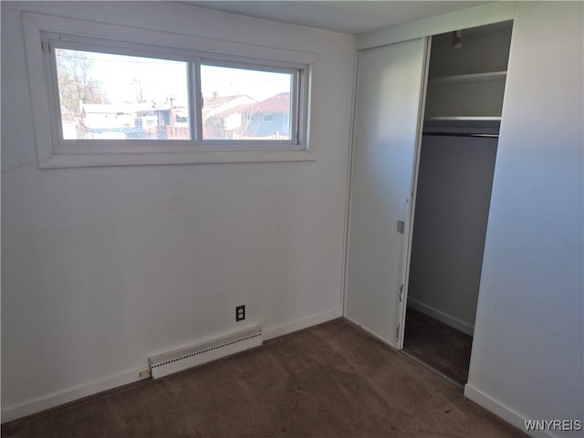 unfurnished bedroom featuring a closet, baseboards, dark colored carpet, and a baseboard radiator