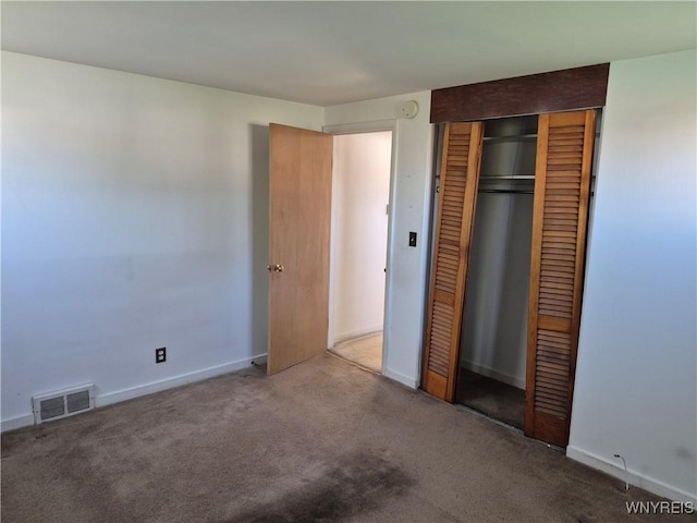 unfurnished bedroom featuring visible vents, baseboards, carpet flooring, and a closet