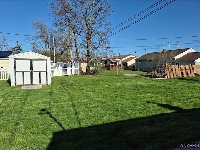 view of yard with an outdoor structure, a fenced backyard, and a storage shed