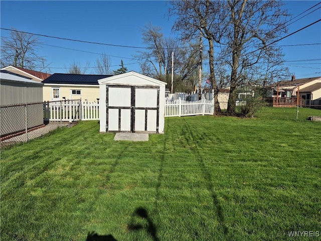 view of yard with an outdoor structure, a fenced backyard, and a storage shed