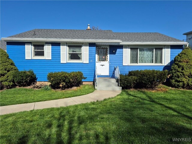 view of front of property featuring roof with shingles and a front yard