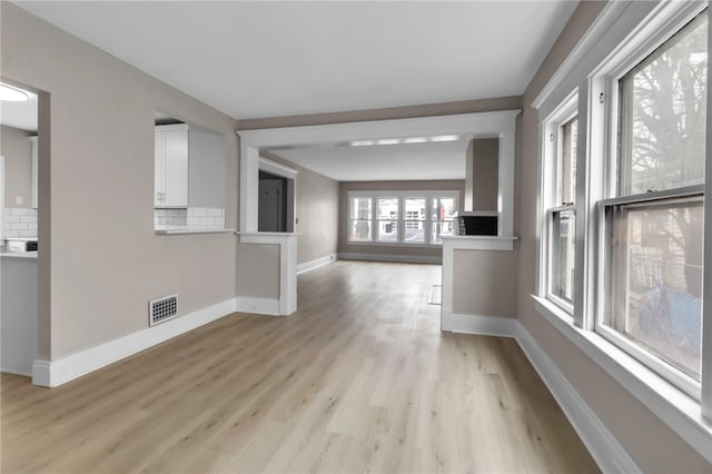 unfurnished room with baseboards, visible vents, and light wood finished floors