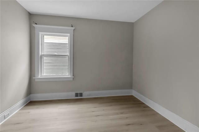 empty room featuring baseboards, visible vents, and light wood-style flooring