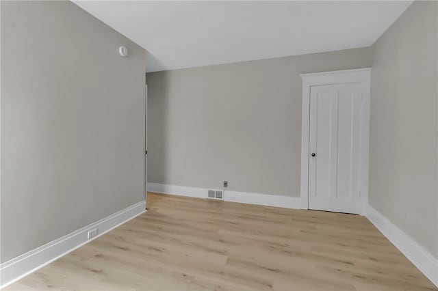 unfurnished room featuring visible vents, light wood-style flooring, and baseboards