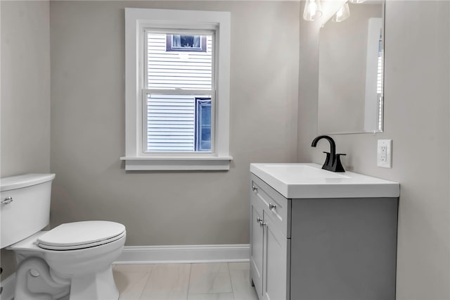 half bath featuring vanity, toilet, marble finish floor, and baseboards