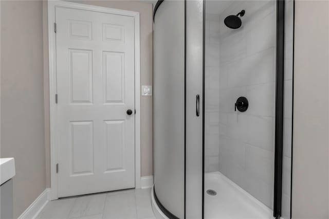 full bathroom featuring vanity, tile patterned flooring, a stall shower, and baseboards