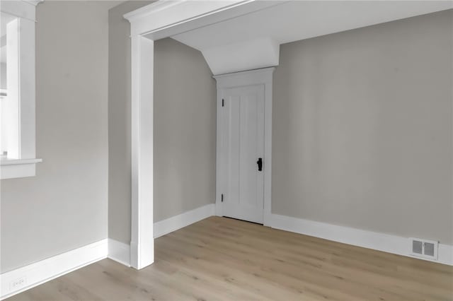 empty room with baseboards, visible vents, and wood finished floors