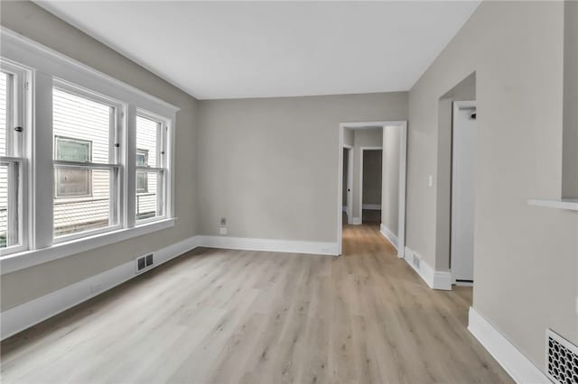 unfurnished room with visible vents, baseboards, and light wood-type flooring