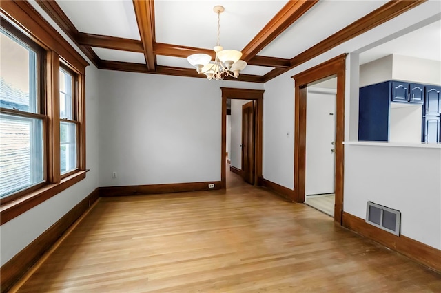 spare room featuring visible vents, coffered ceiling, baseboards, an inviting chandelier, and beam ceiling