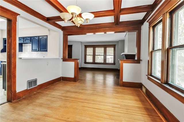 interior space featuring a healthy amount of sunlight, a chandelier, and light wood-style floors