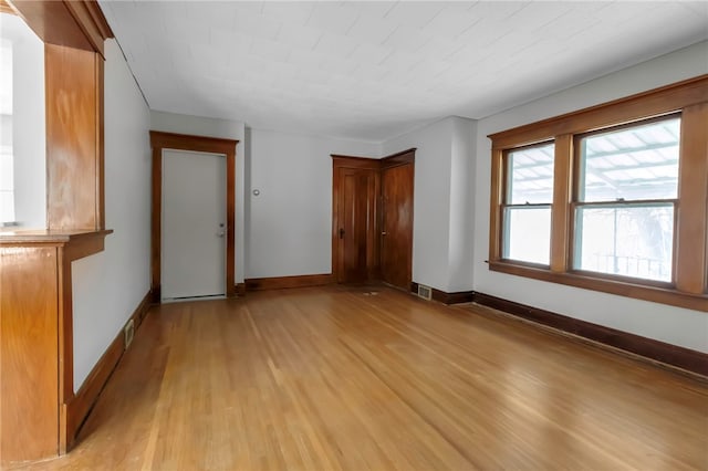 interior space featuring light wood-style floors, visible vents, and baseboards