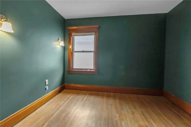 spare room featuring wood finished floors and baseboards
