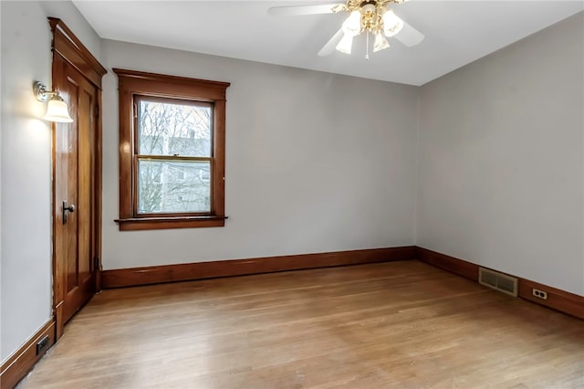 unfurnished room with a ceiling fan, visible vents, light wood-style flooring, and baseboards