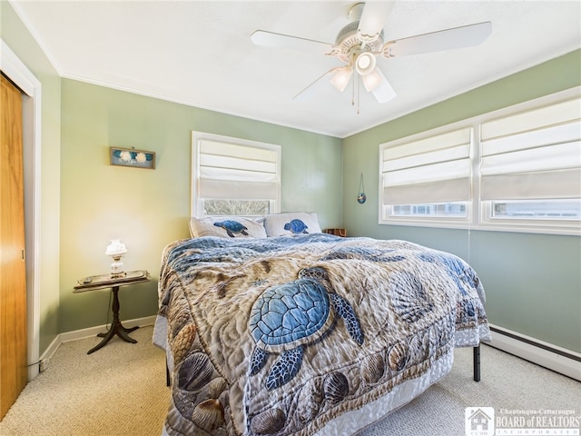 bedroom with a baseboard radiator, multiple windows, baseboards, and carpet floors