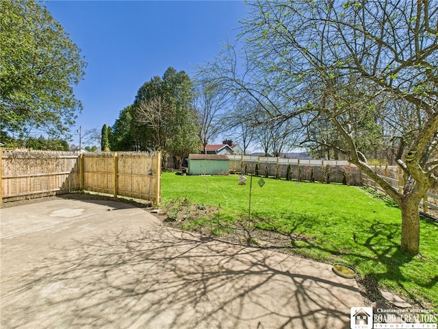 view of yard featuring a storage shed, a patio, an outdoor structure, and a fenced backyard