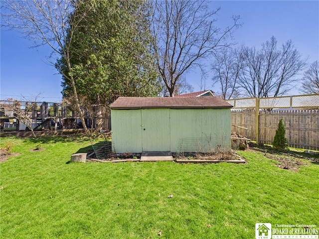 view of yard with a storage unit, fence, and an outbuilding