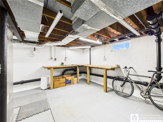 below grade area featuring a workshop area and concrete block wall