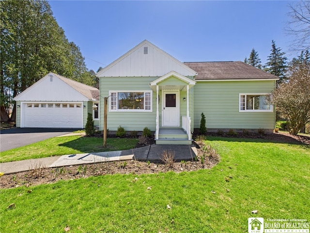 view of front of home with a detached garage and a front yard