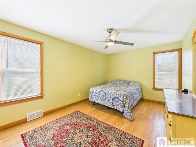 bedroom featuring visible vents, wood finished floors, and baseboards