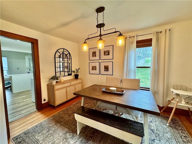 dining area with baseboards and wood finished floors