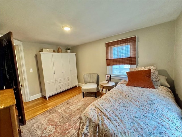 bedroom with wood finished floors and baseboards