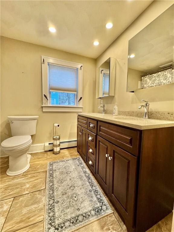 full bath with recessed lighting, double vanity, baseboard heating, toilet, and a sink