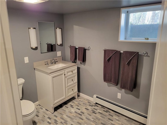 half bath featuring baseboards, a baseboard radiator, toilet, and vanity