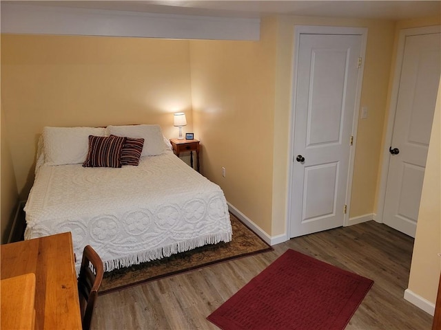 bedroom featuring baseboards and wood finished floors