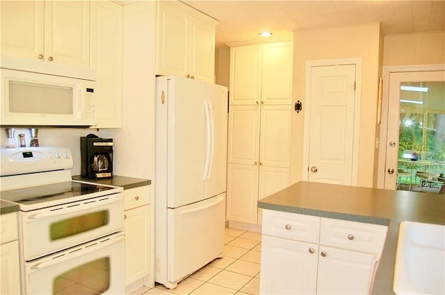 kitchen with light tile patterned flooring, dark countertops, white appliances, recessed lighting, and white cabinets