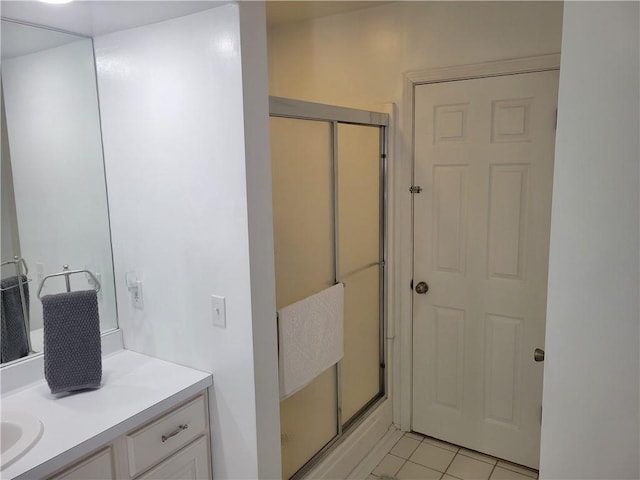 full bath with vanity, a shower with door, and tile patterned floors