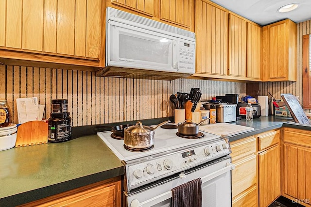kitchen featuring dark countertops and white appliances