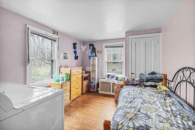 bedroom featuring light wood-type flooring and independent washer and dryer