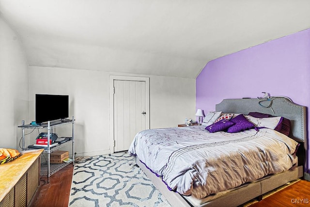 bedroom with wood finished floors and vaulted ceiling