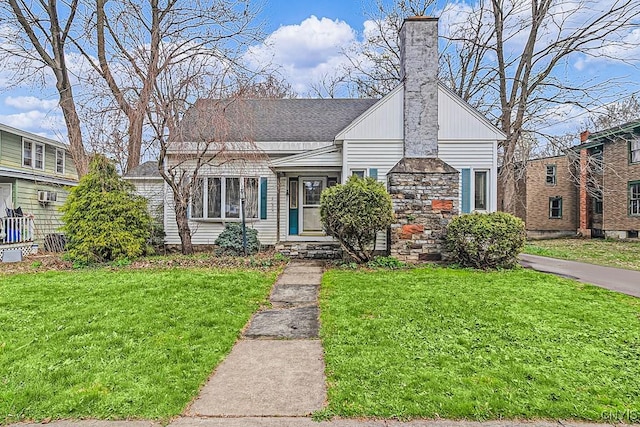 bungalow with a chimney, a front yard, and roof with shingles