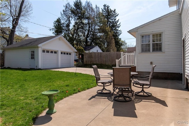 117 Proctor Blvd, Utica, NY 13501 - view of patio / terrace featuring a detached garage, fence, outdoor dining space, and an outbuilding