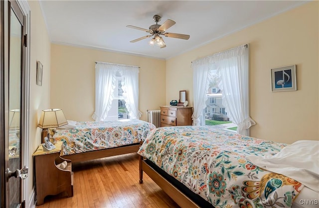 117 Proctor Blvd, Utica, NY 13501 - bedroom with ornamental molding, a ceiling fan, radiator heating unit, and light wood-style flooring