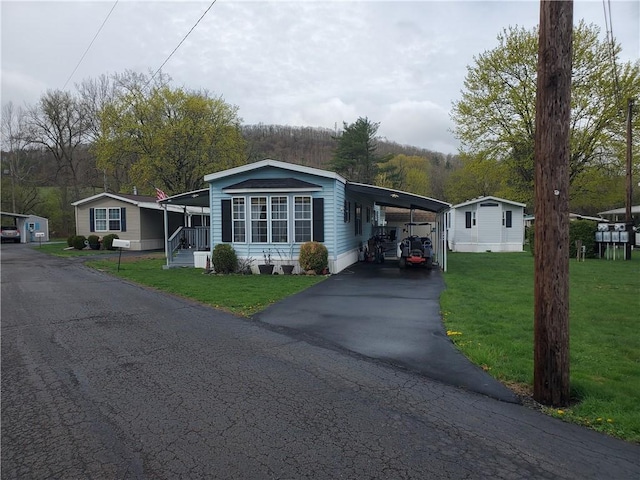 view of front facade with a front yard, a carport, and aphalt driveway