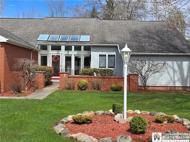 view of front of home featuring a front yard and roof with shingles