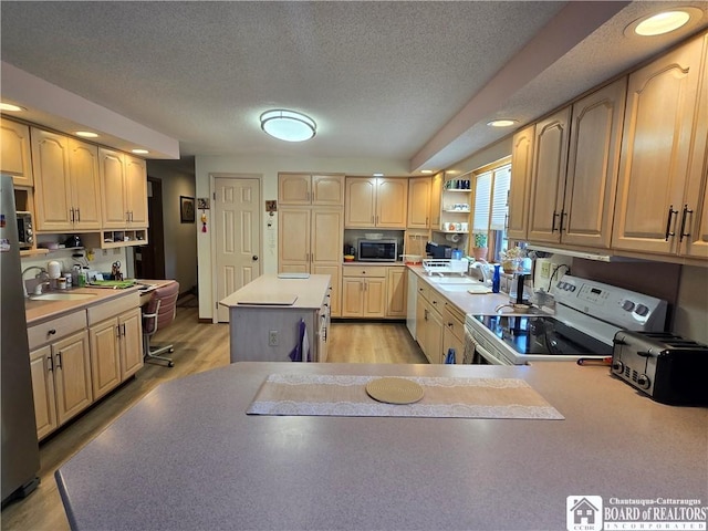kitchen with a textured ceiling, open shelves, stainless steel appliances, and light countertops