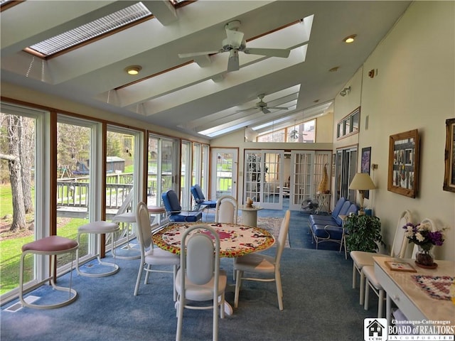 sunroom / solarium featuring french doors, a healthy amount of sunlight, vaulted ceiling with skylight, and carpet