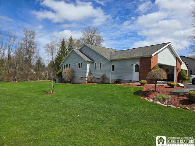 rear view of property with a garage, roof with shingles, and a lawn