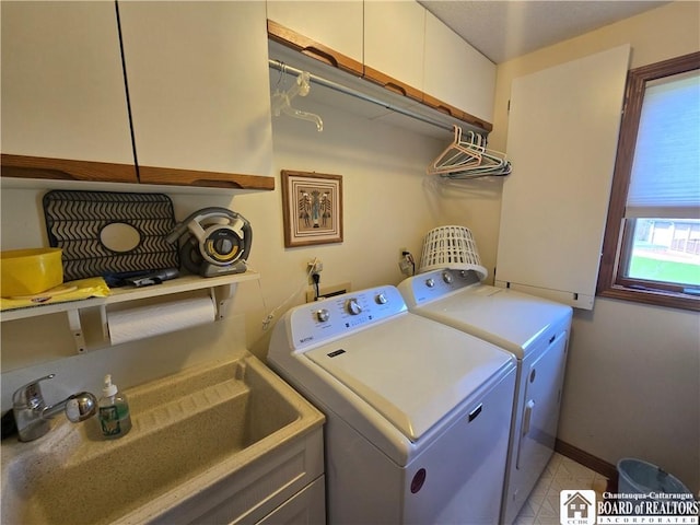 laundry area featuring independent washer and dryer, light tile patterned floors, cabinet space, a sink, and baseboards