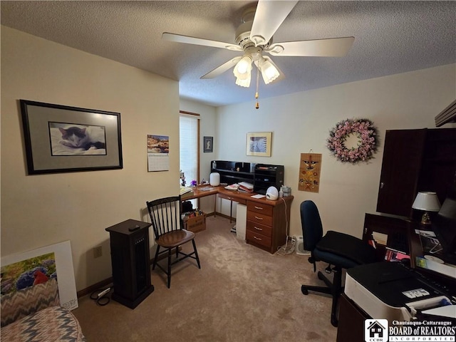 home office featuring baseboards, ceiling fan, a textured ceiling, and light colored carpet