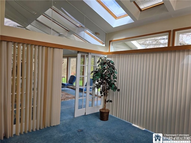 interior space featuring a skylight, french doors, and carpet floors