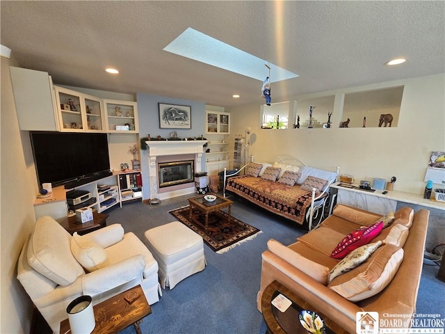 living room featuring a textured ceiling, a glass covered fireplace, recessed lighting, and carpet flooring
